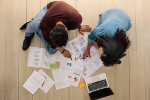 家の図面をみながら考える夫婦の画像